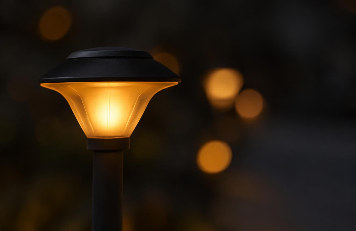 Warm amber landscape path light glowing at night